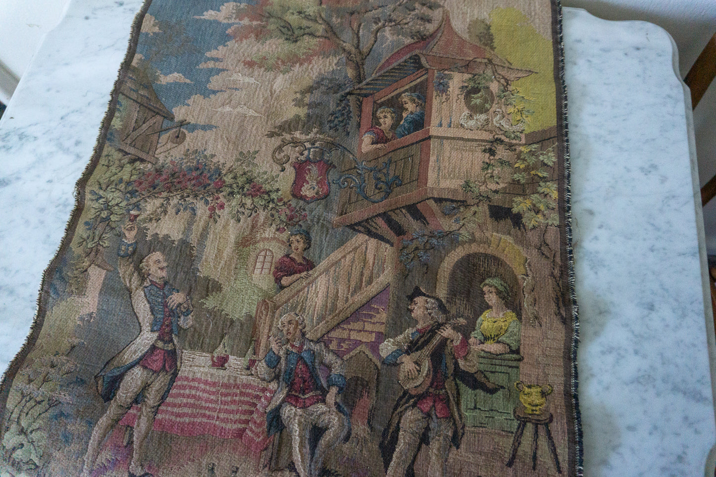 Full view of the vintage Belgian tapestry wall hanging depicting a lively village gathering.