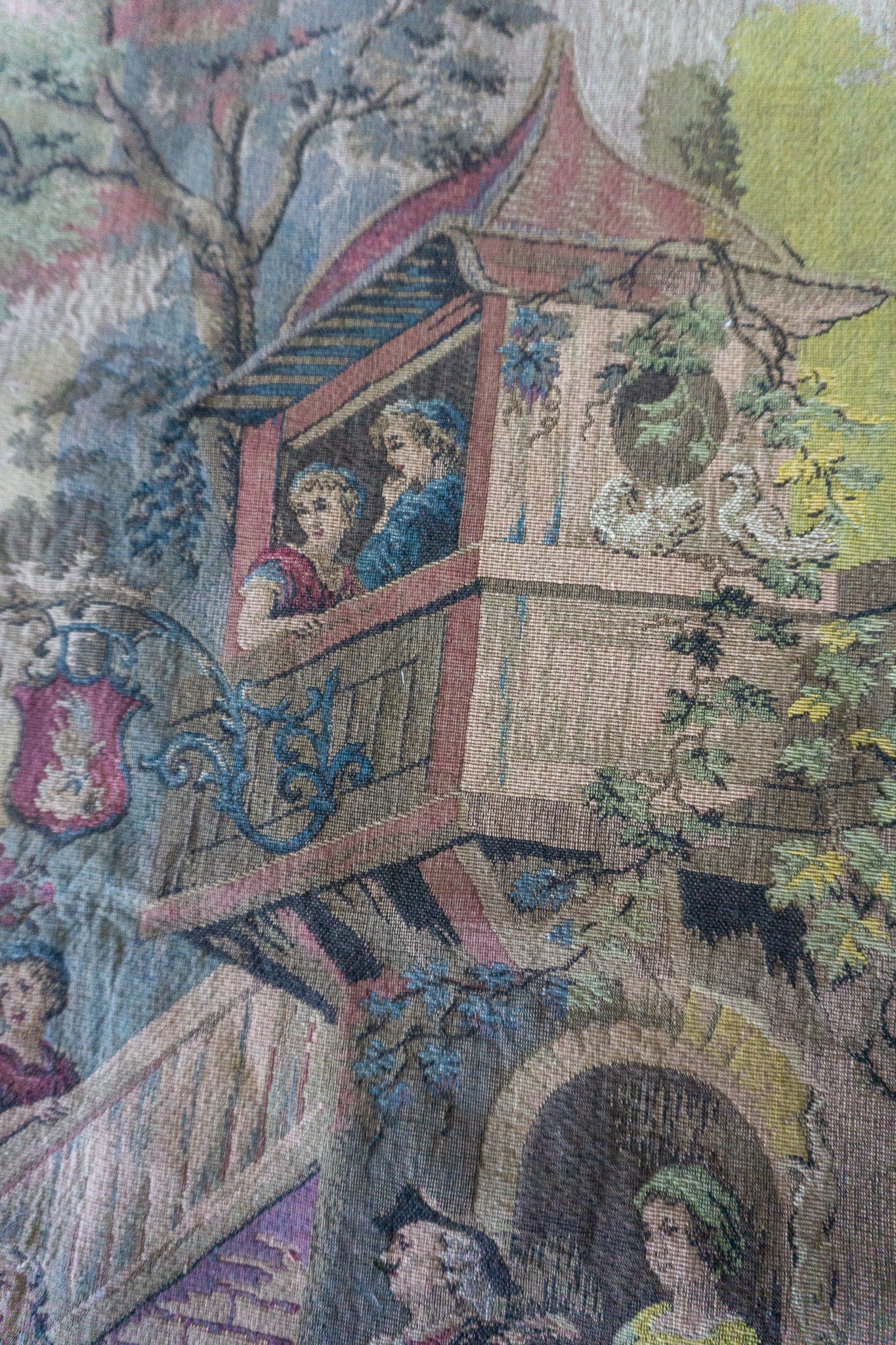 Detailed view of the upper section of the tapestry showing a couple on a balcony.
