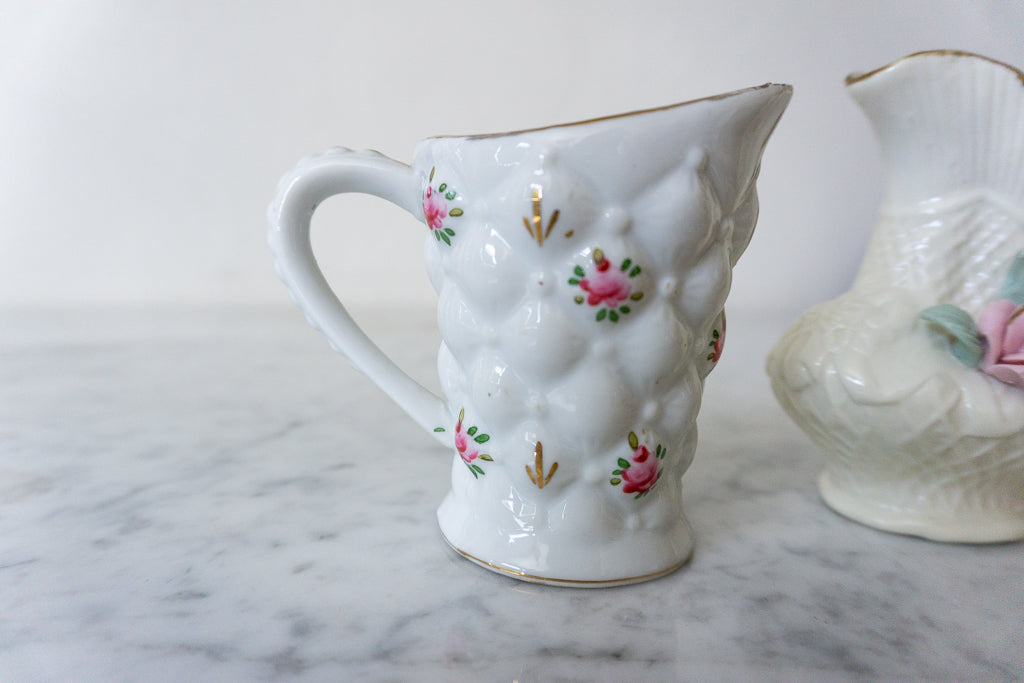 Close-up of floral pitcher with crafted rose arrangement