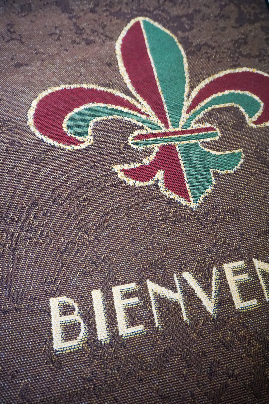 Close-up of Fleur-de-Lis 'Bienvenue' tapestry wall hanging's intricate embroidery.