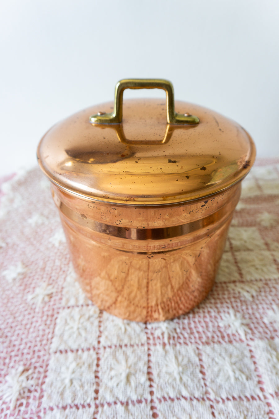 Vintage copper ice bucket with white liner and lid, styled for bar cart or warm-toned kitchen decor.