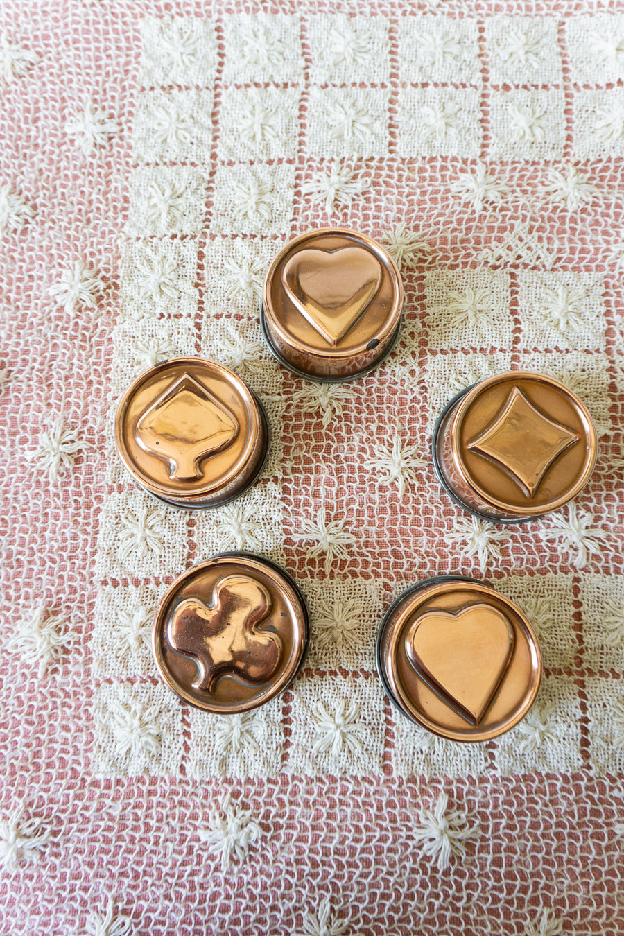 Set of five vintage-style mini copper kitchen molds in assorted shapes, ideal for wall decor or retro kitchen styling.