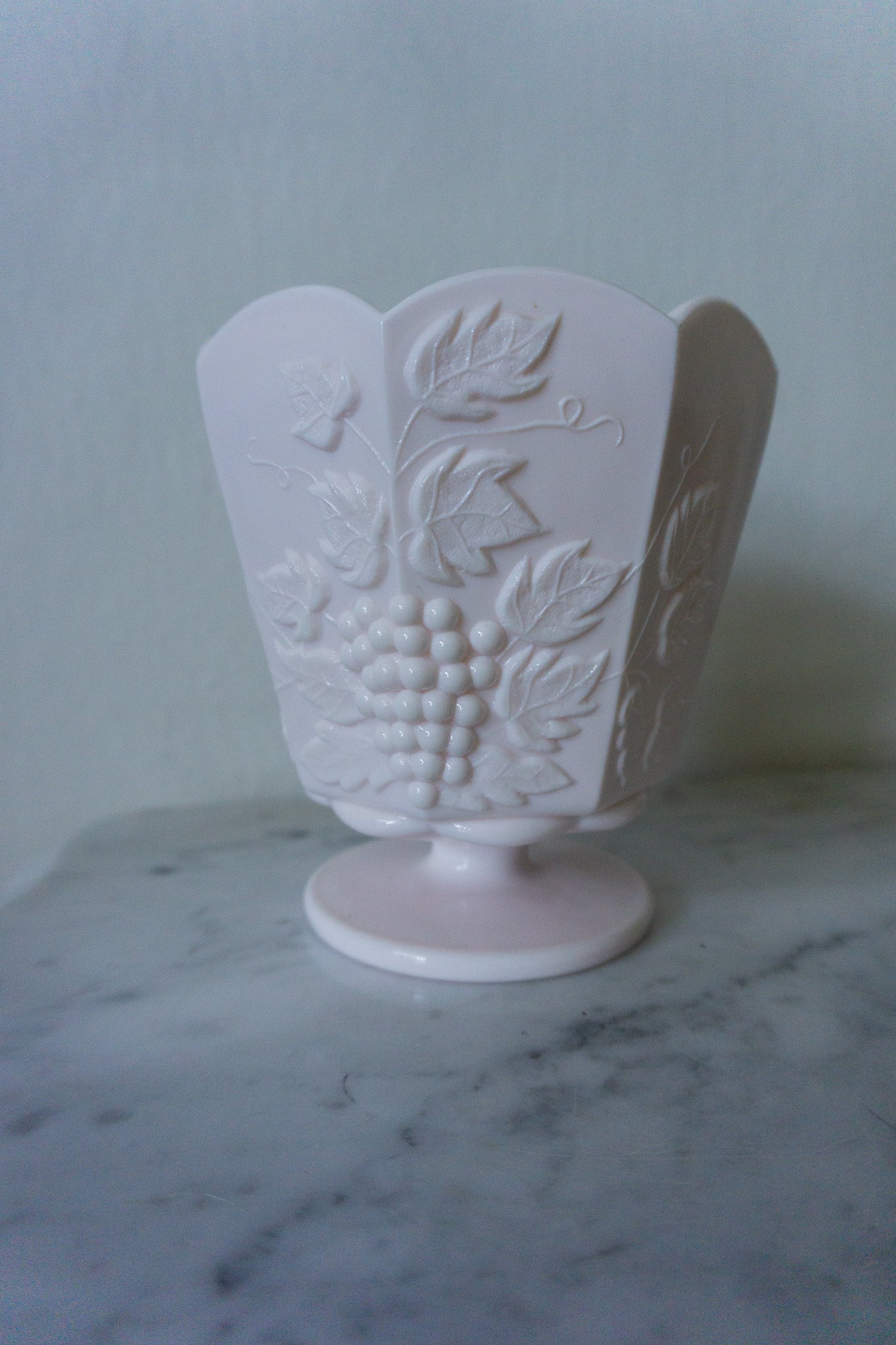 Pink milk glass pedestal dish with embossed grape and vine pattern