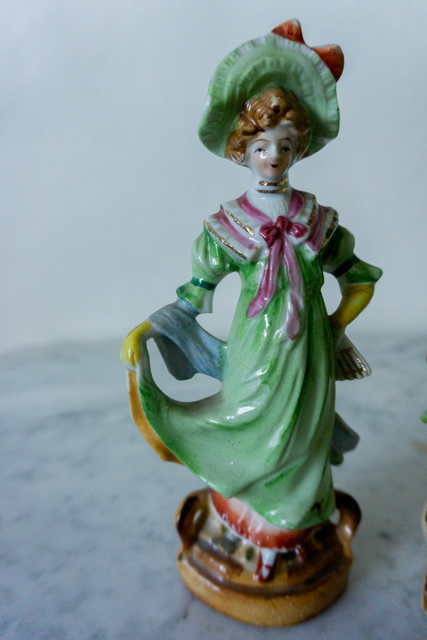 Close-up of the hand-painted Victorian lady figurine in a green dress.