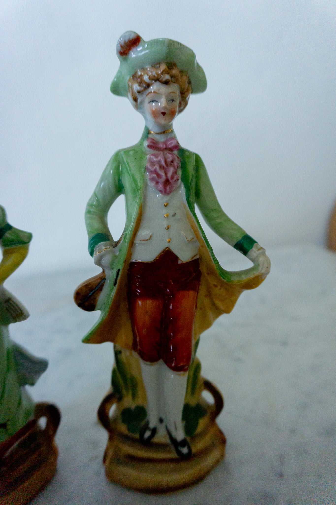 Close-up of the hand-painted Victorian gentleman figurine in a green coat.