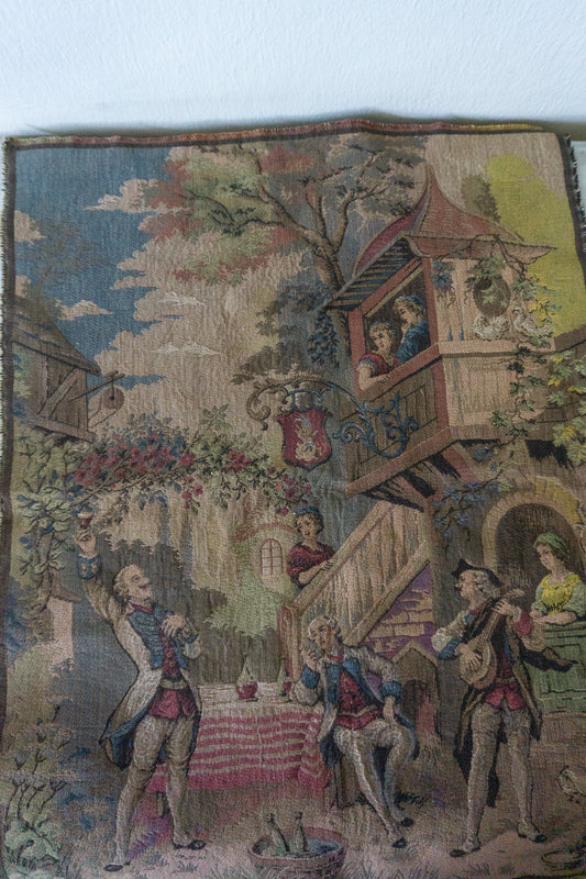 Close-up of vintage Belgian tapestry showcasing an intricate village scene with elegantly dressed figures.