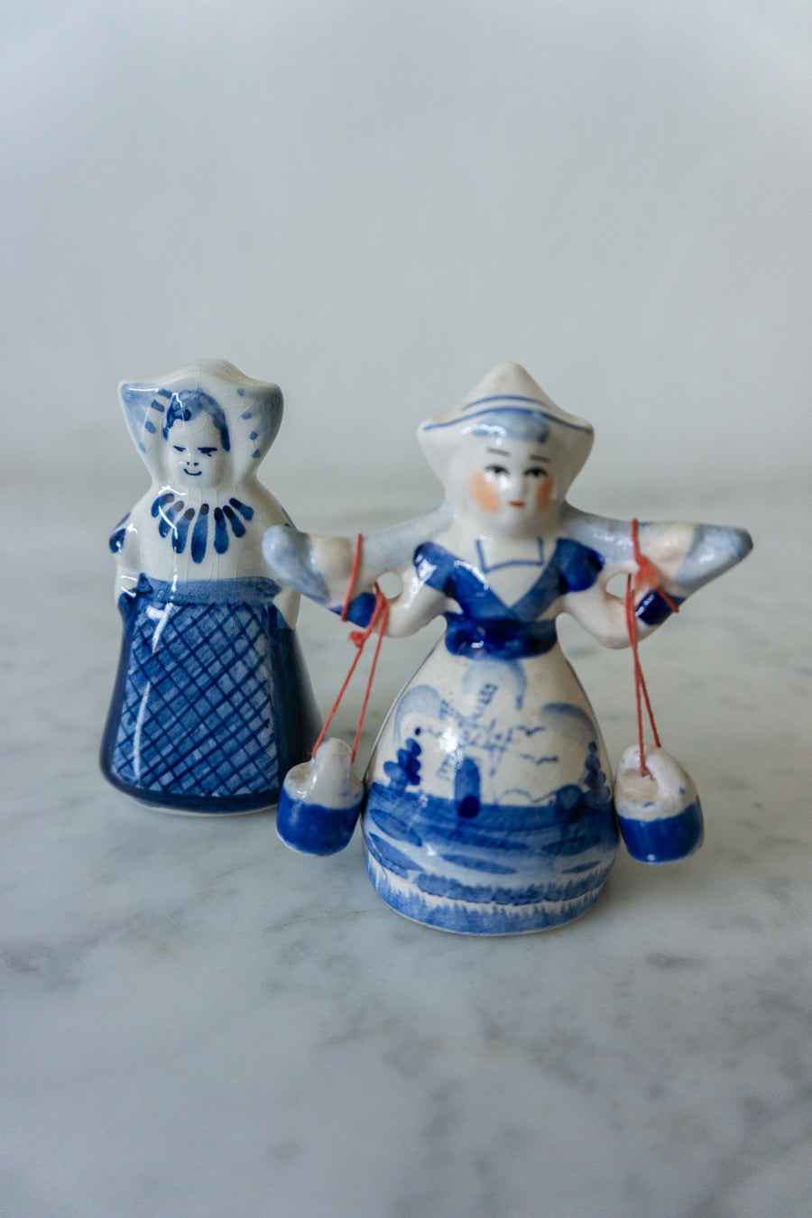 Close-up of Vintage Delft Blue Dutch Milkmaid Figurine, showcasing detailed hand-painted design.