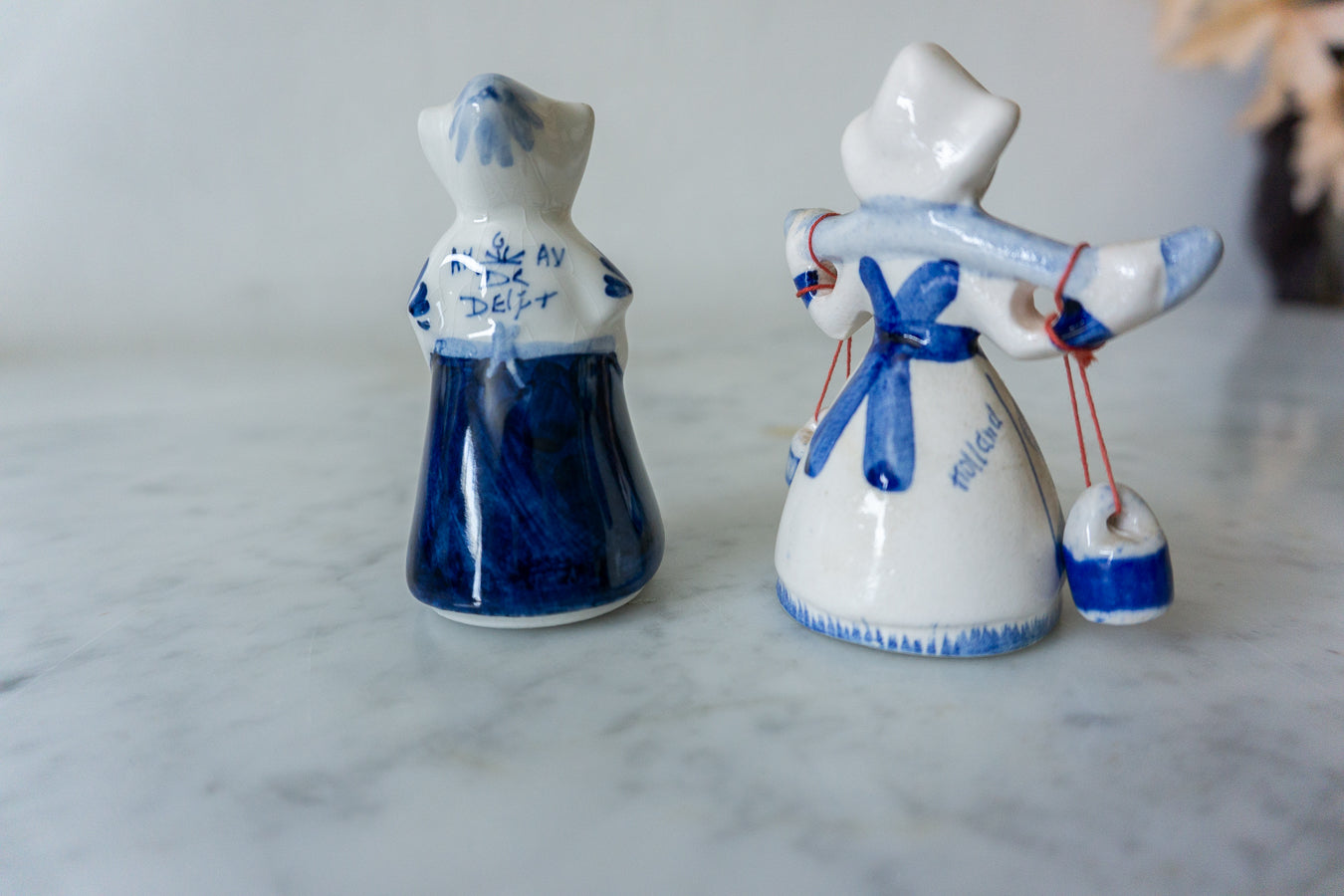 Vintage Delft Blue Dutch Lady Figurine with traditional attire, side view.