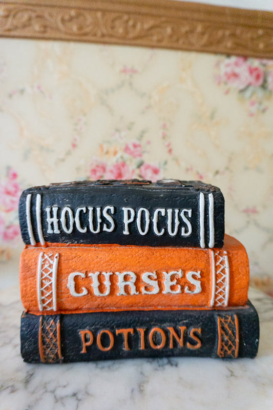 Close-up of Halloween Resin Books Stack with "Hocus Pocus," "Curses," and "Potions."