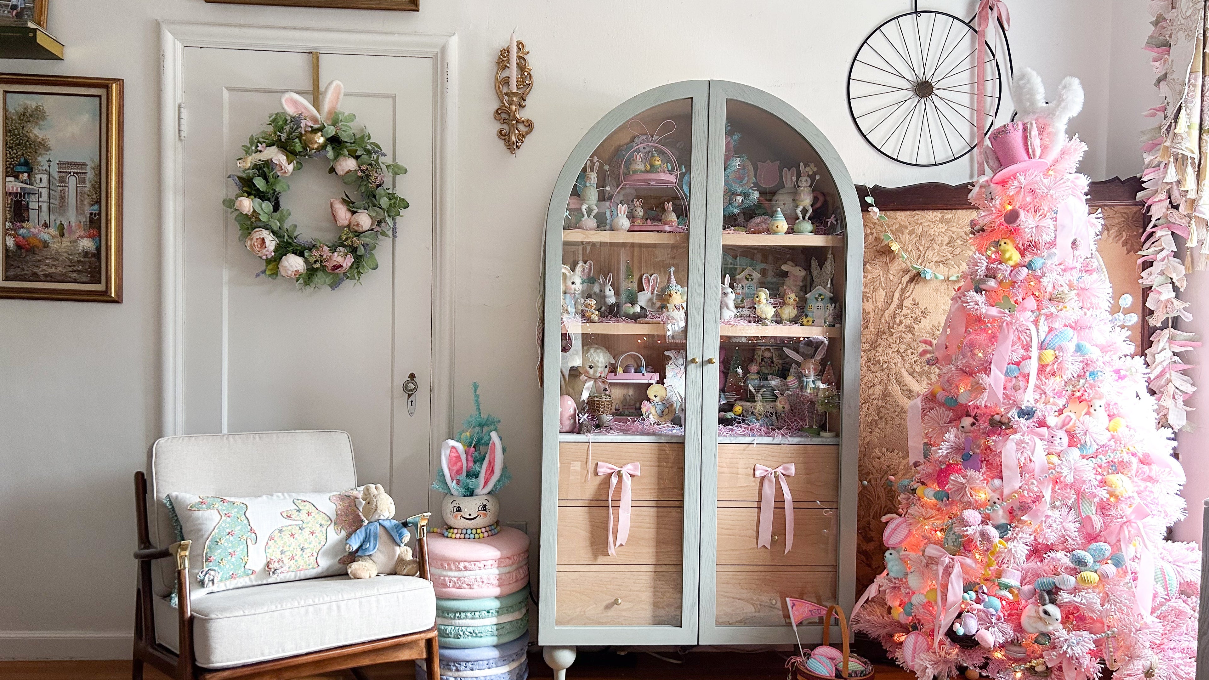Living room with a pink Easter tree, cabinet filled with vintage style spring decor.