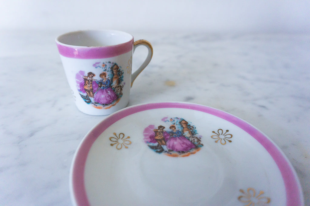 Close-up of the Victorian couple design on the miniature cup and saucer