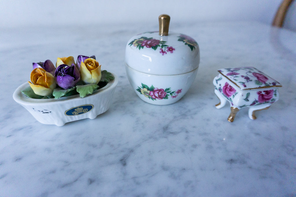 Rectangular trinket box with floral designs and gold-tone legs.