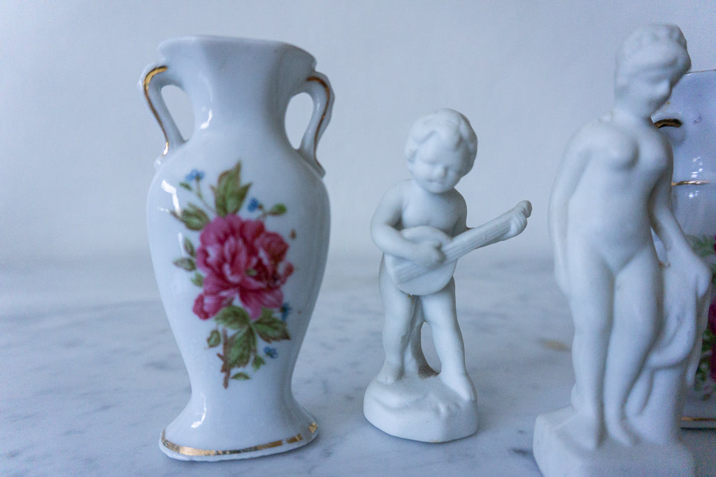 Close-up of porcelain miniature vases with floral designs and figurines