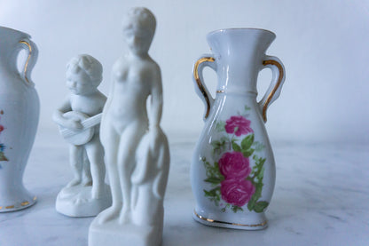 Classic nude porcelain figurine with vases in background