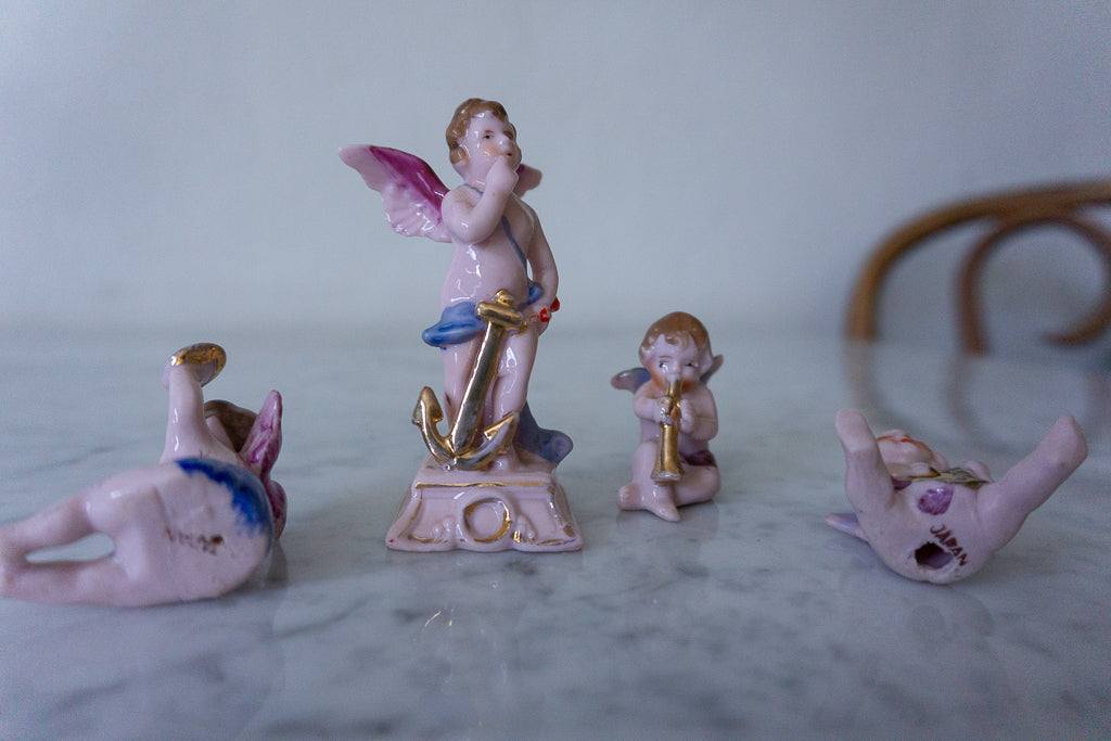 Rear view of the ceramic cherub figurines showcasing their wings and detailed painting.