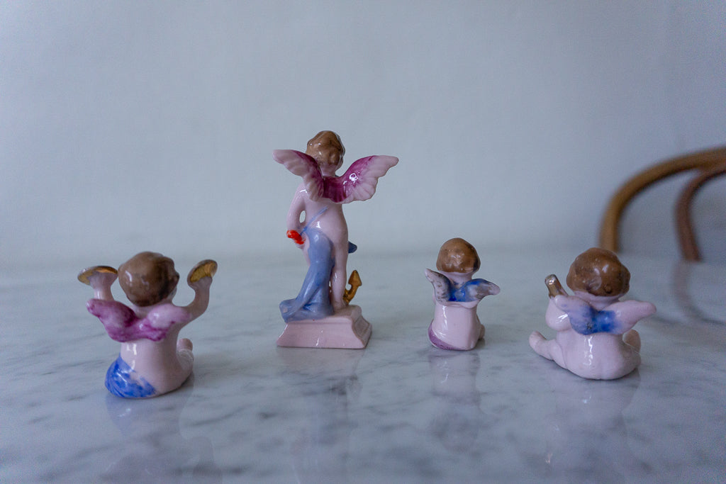 Side view of the hand-painted cherub figurines, highlighting the intricate details and musical instruments.