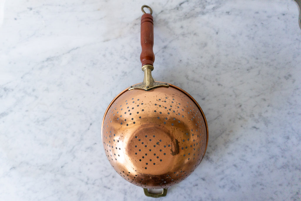 Close-up of a rustic copper colander.