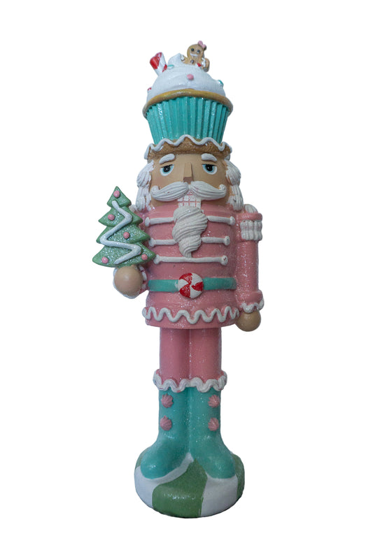 Decorative nutcracker figurine with a cupcake on a white background
