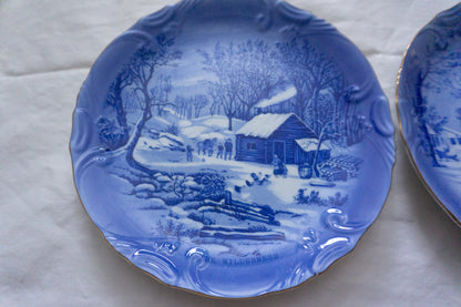 Detailed winter scene decorative plates set in blue and white.