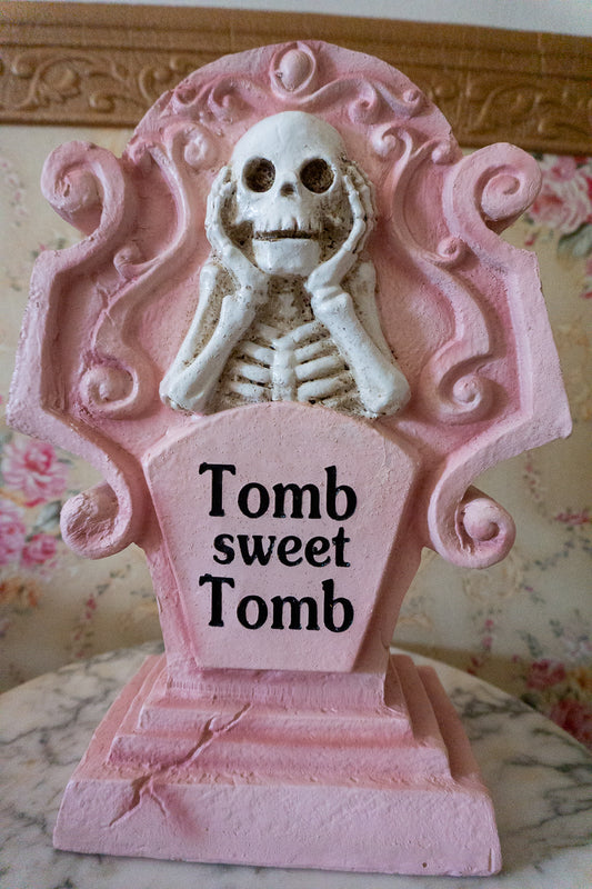 pink halloween decor tombstone with skeleton