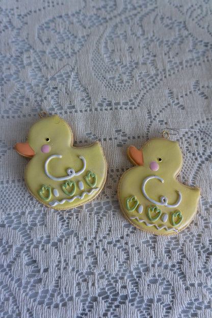 Set of 2 chick cookie ornaments on lace background for spring decor.