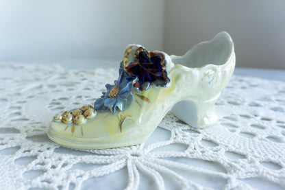Porcelain decorative shoe with iridescent glaze, blue floral embellishments, and gold accents – vintage-style tabletop decor made in Germany